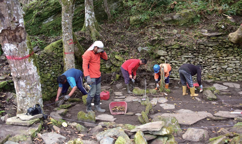 重建佳心石板屋，族人與中研院史語所考古團隊，進行清理地表植被及測繪的工作。圖片提供：健行文化