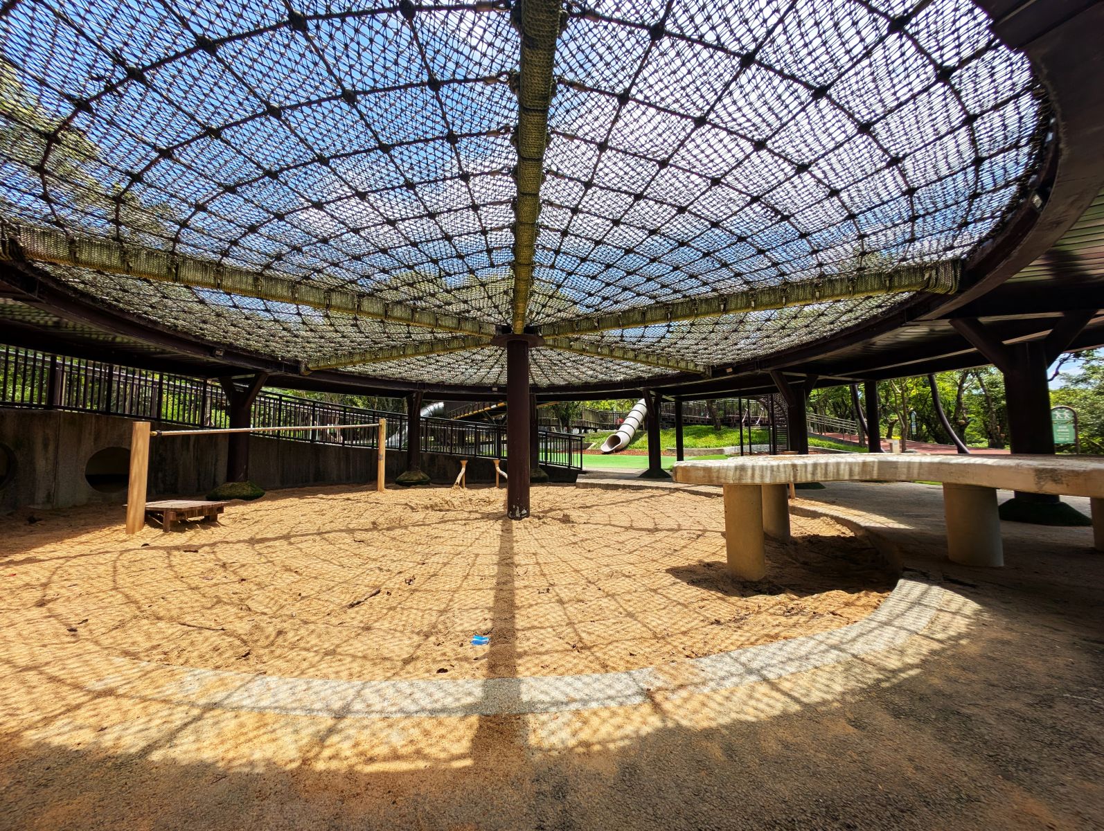 南港公園的沙坑上方是麻繩網,除了作為孩子攀爬玩耍的遊具,更為沙坑帶來遮蔭,底下沙子溫暖不燙。攝影:陳昭宏